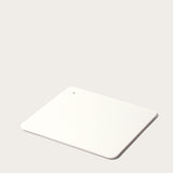 A minimalist, rectangular white Gather 2x2 Organizer Set with rounded corners and a corner hole, crafted from powder-coated steel to match your customizable desk organizer—shown on a light, neutral background.