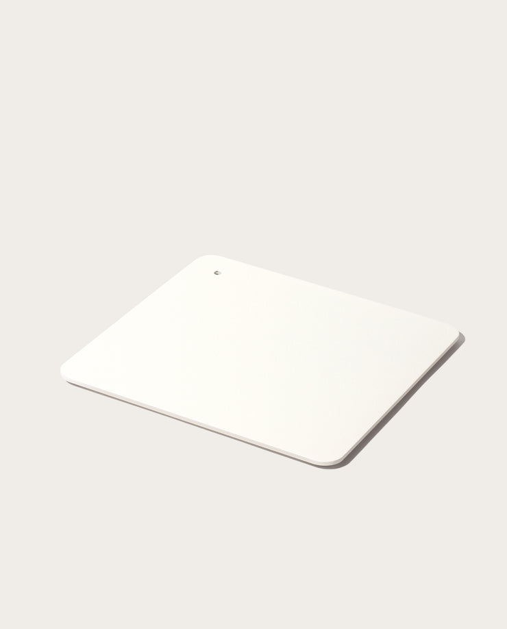 A minimalist, rectangular white Gather 2x2 Organizer Set with rounded corners and a corner hole, crafted from powder-coated steel to match your customizable desk organizer—shown on a light, neutral background.