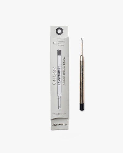 A Black Gel Pen Refill (The Ugmonk Pen) is displayed next to its white packaging. The 0.5mm metallic refill has a black end, and the box shows product details in black text along with an illustration of the refill.