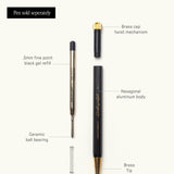 Exploded view of The Ugmonk Pen with Black Gel Pen Refill, showing labeled parts: brass cap, twist mechanism, 0.5mm black gel refill, ceramic ball bearing, spring, hexagonal aluminum body, and brass tip.