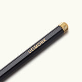 The Ugmonk Pen (Leuchtturm1917 Drehgriffel - Black) features a black body, metallic gold eraser cap, and "UGMONK" printed in gold on the side, shown against a light background.