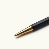 A close-up of The Ugmonk Pen (Leuchtturm1917 Drehgriffel - Black) with a gold tip, displayed diagonally on a plain white background.