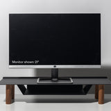 A 21-inch computer monitor rests on the Gather Small Monitor Stand (Black/Walnut) with wooden legs, set against a plain light gray background. The screen is off, displaying the text: “Monitor shown: 21”.”.