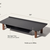 The Gather Small Monitor Stand (Black/Walnut) features four wooden legs, a powder-coated steel top, a tray for up to a 16" laptop, measures 26 x 10.5 x 5 inches, and supports up to 35 lbs.