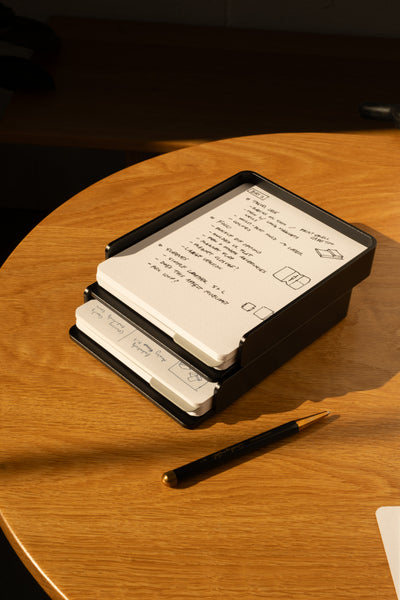 The Analog Capture Kit - 2 Large (Black Aluminum) features dot grid cards in a sleek black aluminum tray, with a pen nearby on a wooden table—everything you need to capture your ideas in style.