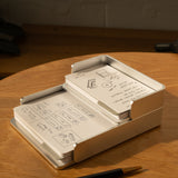 The Complete Analog Collection (Silver Aluminum) neatly holds stacked note cards with sketches and notes on a wooden desk beside a black and gold pen, while warm light casts gentle shadows across the scene.