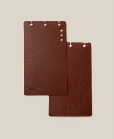 The *Covers Only* – Leather Discbound Analog (Brown) set includes two brown full-grain leather covers, made in the USA, with rounded corners and three top holes—one embossed with "Discbound Analog," one with a small logo—against a beige background.