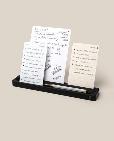 The Analog Card Bar (Small 10" - Black) organizes a gold and black pen with three notecards showing handwritten notes, to-do lists, and diagrams on a neutral beige background.