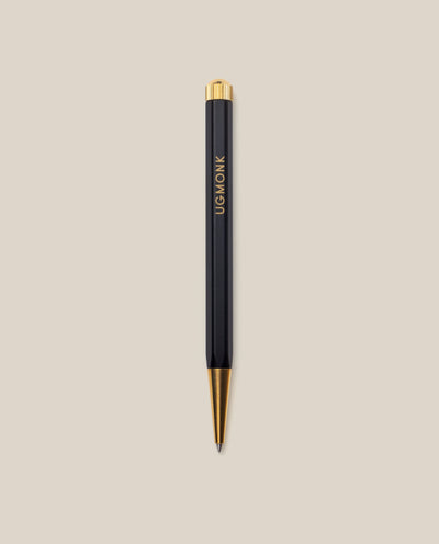 The Ugmonk Pen (Leuchtturm1917 Drehgriffel - Black) features gold accents and "UGMONK" printed vertically on its barrel, shown against a light beige background.