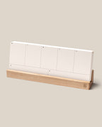 The Analog Weekly Planning Kit (Maple) features seven labeled Weekly Planner Cards—one for each day—displayed on a sleek maple stand against a simple beige background.