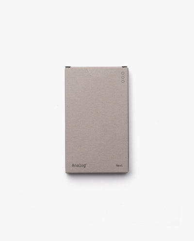 A minimalist light brown box labeled Analog - Next Cards (1-Pack) sits on a white background. Three dots in the top right suggest dot grid cards inside, perfect for goal-setting and organizing your thoughts.