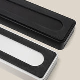 A black Analog Card Bar (Small 10") is shown from above on a light beige background, featuring large black anti-slip rubber pads on the bottom—ideal for complementing any desk organizer or pen tray setup.
