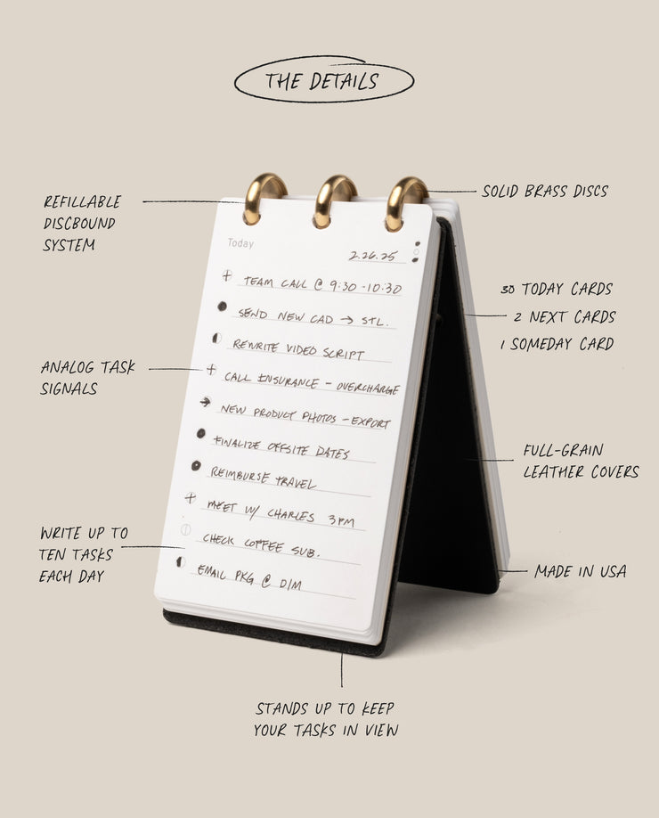 The Leather Discbound Analog (Black) is a compact desktop card organizer with handwritten notes on white cards, brass discs, refillable pages, analog signals, and a stand-up discbound design framed by full-grain leather covers.
