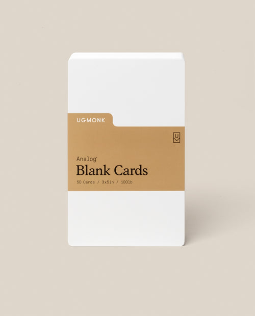 A pack of Analog Blank Cards - Small, made from uncoated cardstock with a brown label reading "Analog Blank Cards, 50 Cards, 3x5in, 100lb," stands upright against a beige background.