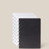 The Discbound Heirloom Journal Bundle in black leather (Standard 6" x 8.5" with 3 refills) is displayed fanned open to show four dotted pages, against a plain beige background.