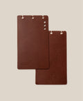 Two brown rectangular *Covers Only* – Leather Discbound Analog (Brown) made from full-grain leather, each with holes along the top edge, are placed on a beige background. One cover is embossed with “Analog,” while the other displays a small logo at the bottom. These Discbound covers are crafted in the USA, reflecting quality craftsmanship and timeless style.