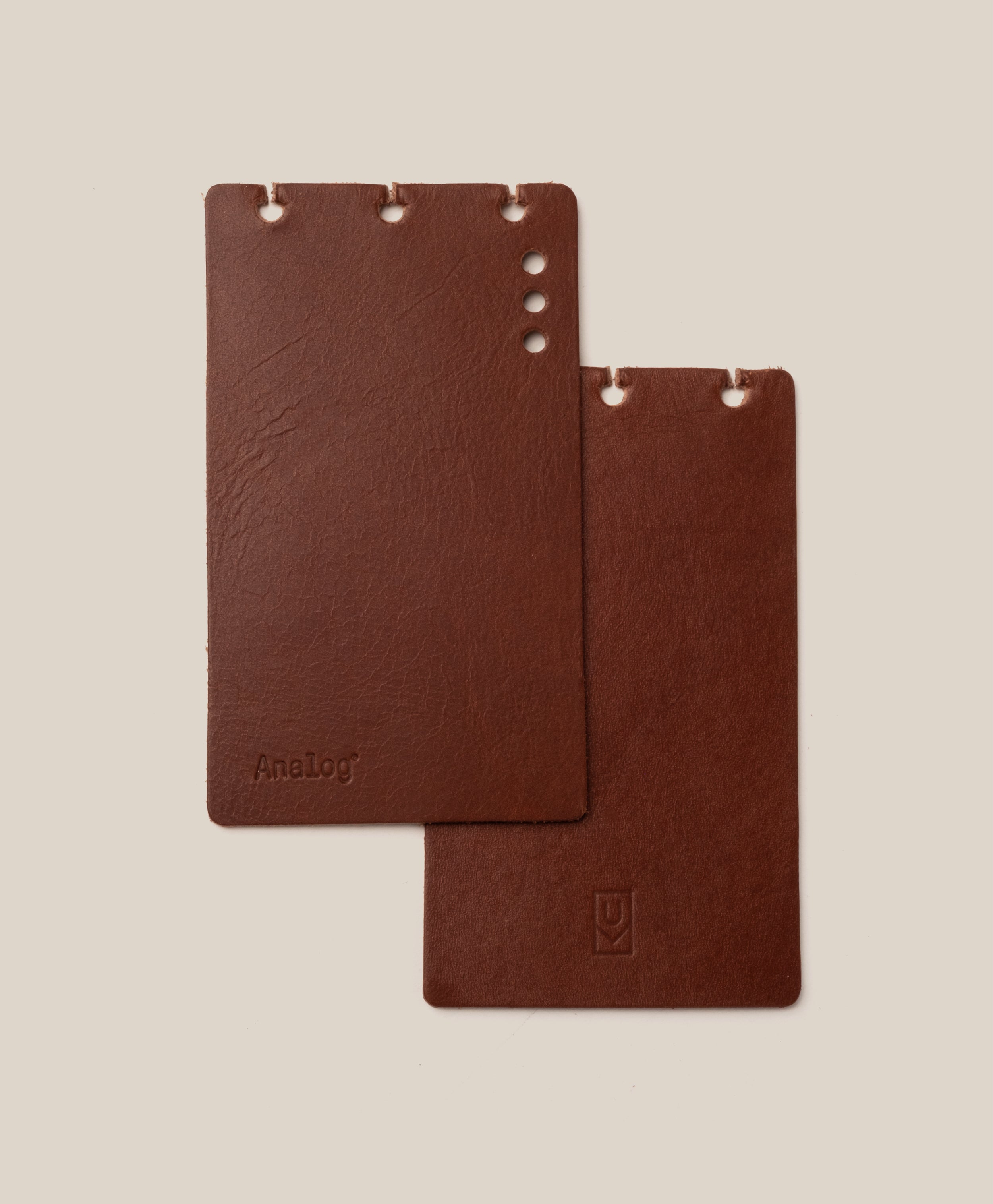 Two brown rectangular *Covers Only* – Leather Discbound Analog (Brown) made from full-grain leather, each with holes along the top edge, are placed on a beige background. One cover is embossed with “Analog,” while the other displays a small logo at the bottom. These Discbound covers are crafted in the USA, reflecting quality craftsmanship and timeless style.