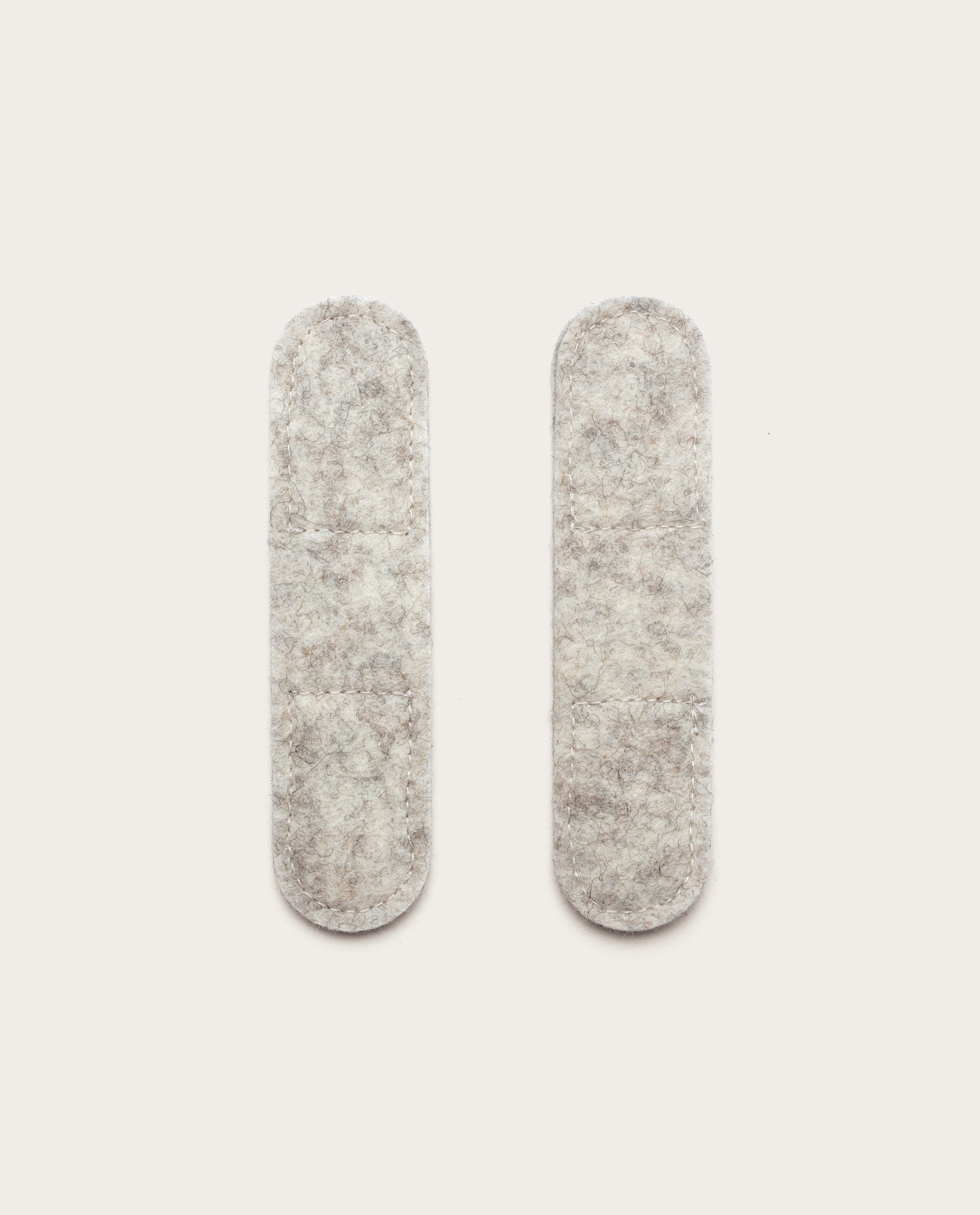 Two light gray, oval-shaped Warehouse Item - Magnetic Cable Keepers (Set of 2 - Light Gray) are placed vertically side by side on a plain white background.