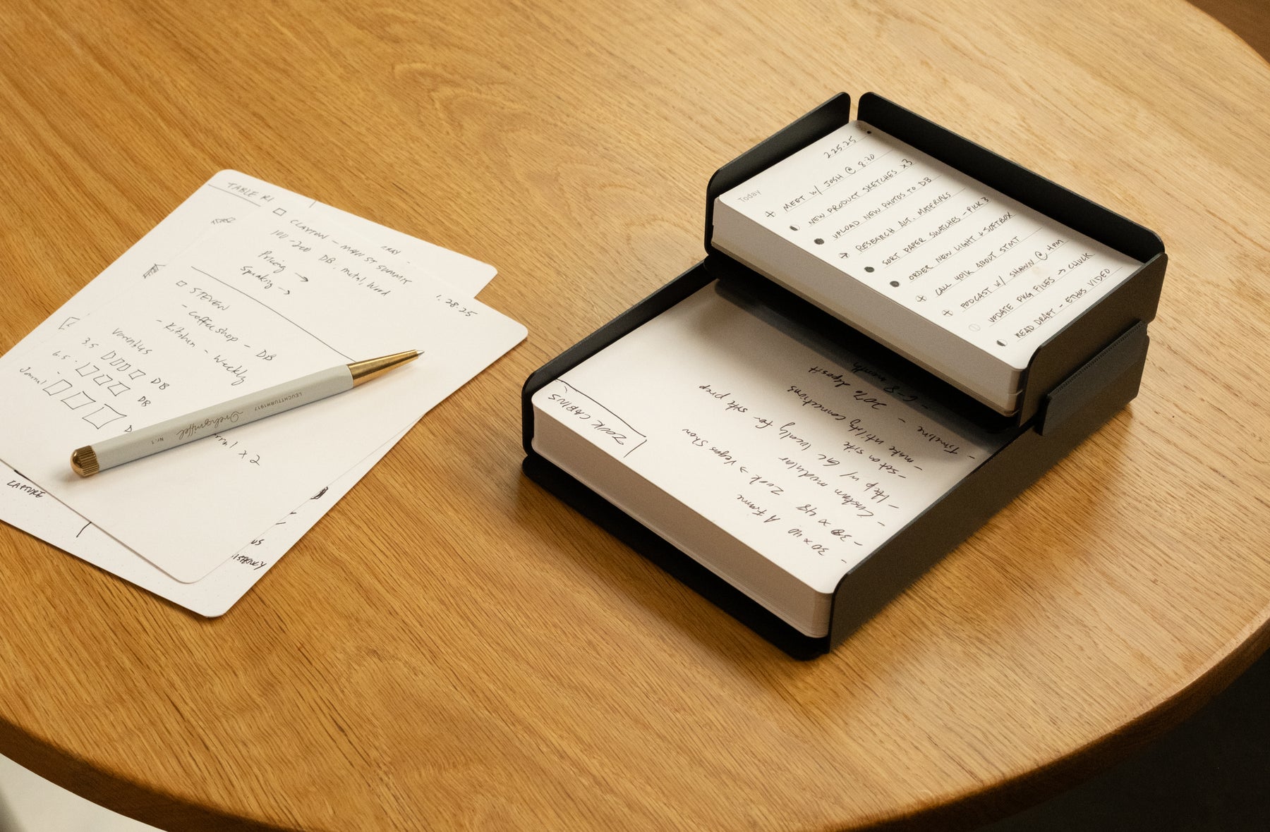 A stack of papers and a pen on a table.