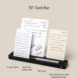 The Analog Card Bar (Small 10" - Black) is a solid aluminum desk organizer with two card slots to hold three notes upright, a pen tray, labeled features for easy use, anti-slip pad, and durable build. Dimensions: 10 × 1.8 × .63 inches.