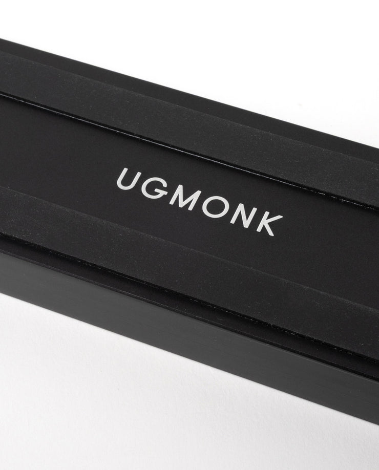 A sleek black rectangular box with "UGMONK" in white capitals on the lid, ideal for storing the Analog Card Bar (Small 10" - Black), photographed against a white background.