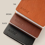 Three Leather Discbound Analog notebooks in tan, brown, and black with full-grain leather covers are stacked diagonally on a beige background. Each has "Analog" embossed on the cover with color labels beside each notebook.