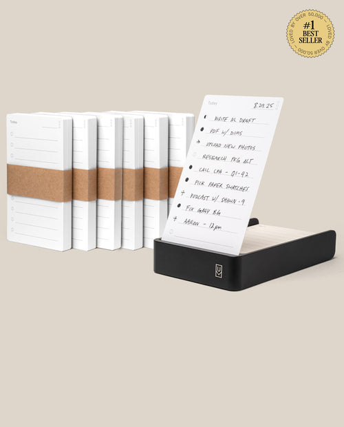 The Analog Daily Focus Kit + 6 Refills (Black Aluminum) is a sleek desktop organizer with stacked Analog Task Cards in a black holder, bundled notecard refills behind it, and a to-do list card marked with a #1 Best Seller badge in the top right.