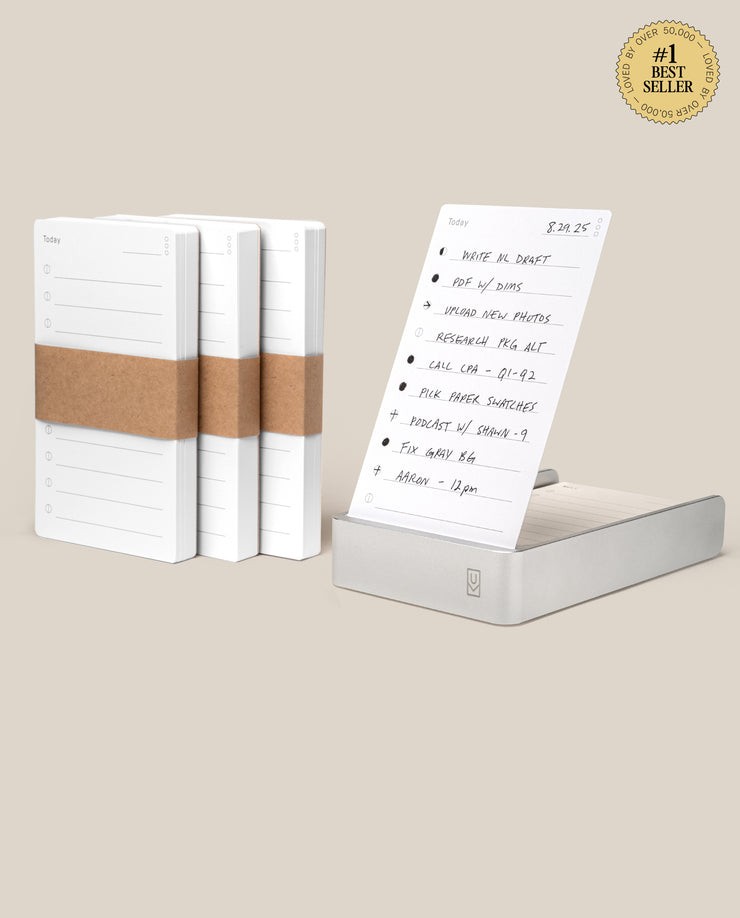 Four stacks of Analog Daily Focus Kit + 3 Refills (Silver Aluminum) task cards are shown; one stack sits in a sleek silver aluminum holder displaying a handwritten to-do list. A #1 Best Seller badge appears in the top right corner.