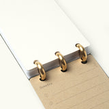 The Discbound Analog + 3 Refills features gold rings, a blank dotted grid page on top, and a lined brown "Someday" page with note icons underneath—ideal for flexible, refillable task planning.