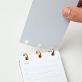 A hand opens the Discbound Analog + 3 Refills, featuring a dotted translucent cover and brass disc binding. Inside, a "Today" page offers lined circles for tasks—making it your ideal refillable daily task planner.