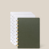 The Discbound Journal Bundle (Standard 6"x 8.5" Journal + 3 Refills) is shown partially open, featuring a dark green cover with gold rings and white dot grid paper, set against a plain beige background.