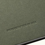 The Discbound Journal Bundle features a textured olive-green cover embossed with "HANDCRAFTED IN USA" in uppercase, ideal for your refillable 6"x8.5" journal and three dot grid paper refills.