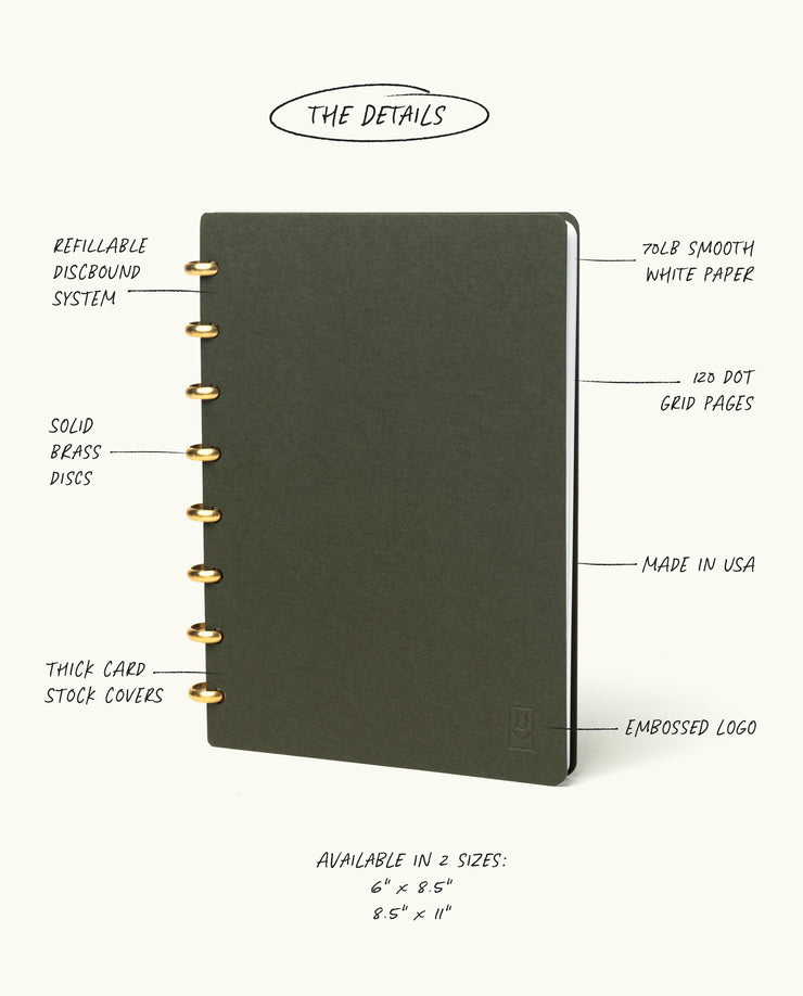 The Discbound Journal (Standard 6"x 8.5") is a dark, spiral-bound, refillable notebook with solid brass discs, thick card stock covers, 70lb smooth white paper, 120 dot grid pages, an embossed logo, and is made in the USA.