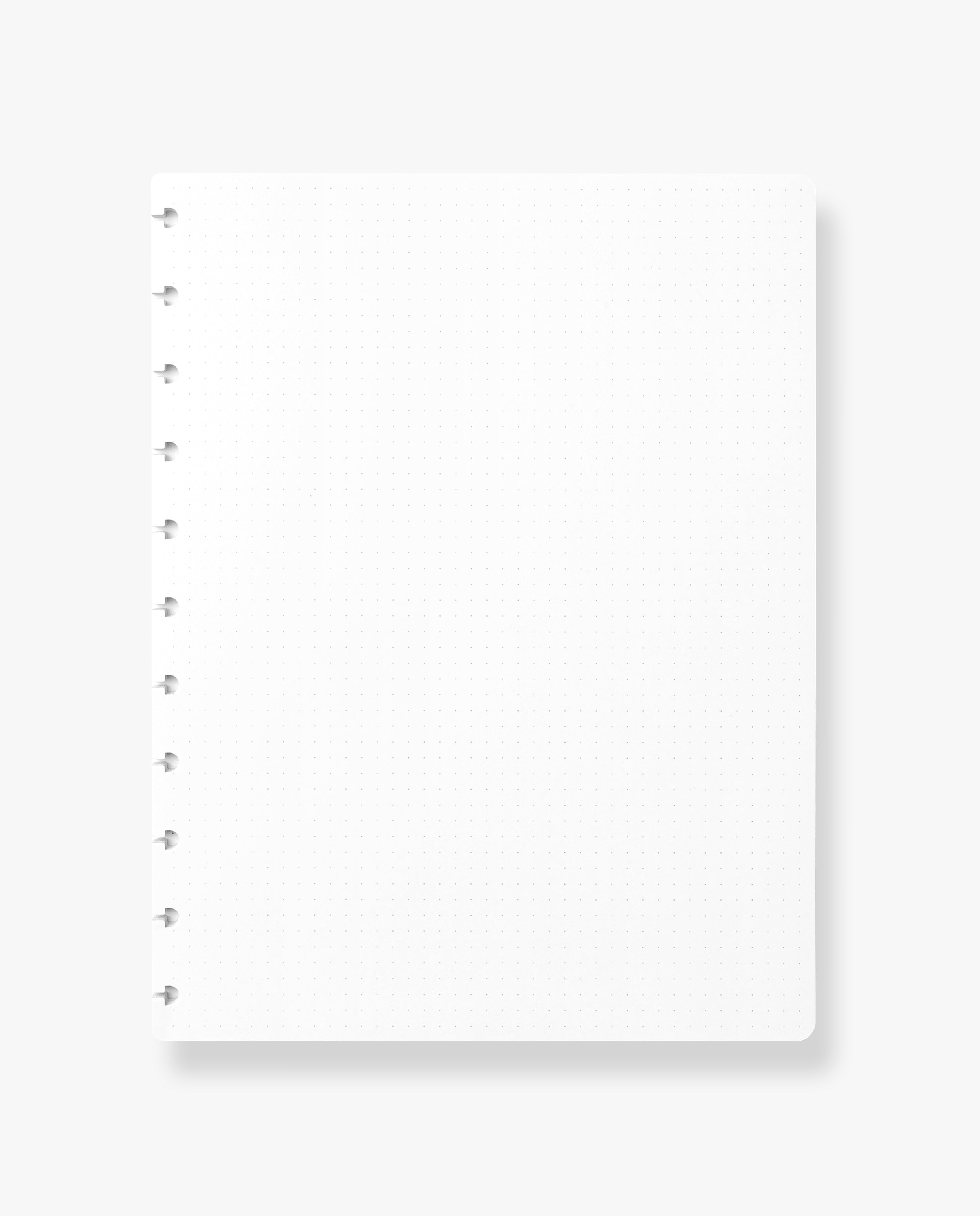 The Discbound Journal Refill (8.5" x 11") features a blank, white dot grid notebook page with left-side spiral binding, set against a light background—ideal for refilling your discbound journal and enhancing your note-taking experience.