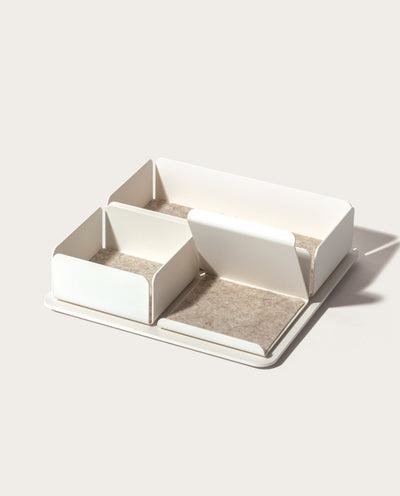 The Gather 2x2 Organizer Set (White) is a rectangular, minimalist desk organizer with three varied compartments on a flat powder-coated steel base. Each compartment is lined with light beige felt and placed against a plain, light background.