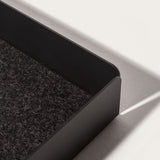 A close-up of the Gather Large Tray (2x2 - Black) featuring a textured dark felt interior and magnetic base, casting a shadow on a white surface in bright light.