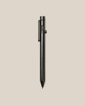 The INVENTERY Bolt Action Pen (Zirconium), featuring a sleek black metal design and a sturdy clip, stands upright against a plain light beige background.