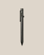 The INVENTERY Bolt Action Pen (Zirconium), featuring a sleek black metal design and a sturdy clip, stands upright against a plain light beige background.