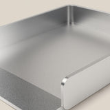 A close-up of the Analog Capture Kit - Small & Large (Silver Aluminum), a rectangular tray with raised sides and open front, ideal for organizing Dot Grid Cards, shown on a light beige surface.