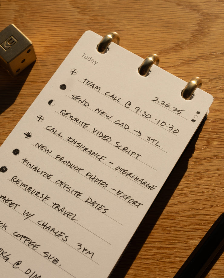 Notebook with handwritten to-do list on a wooden surface