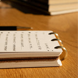 Open notebook with handwritten notes on a wooden surface