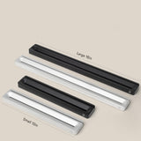 A slim, rectangular Analog Card Bar (Small 10" - Black) desk organizer rests on a beige background, alongside silver and large-size options.