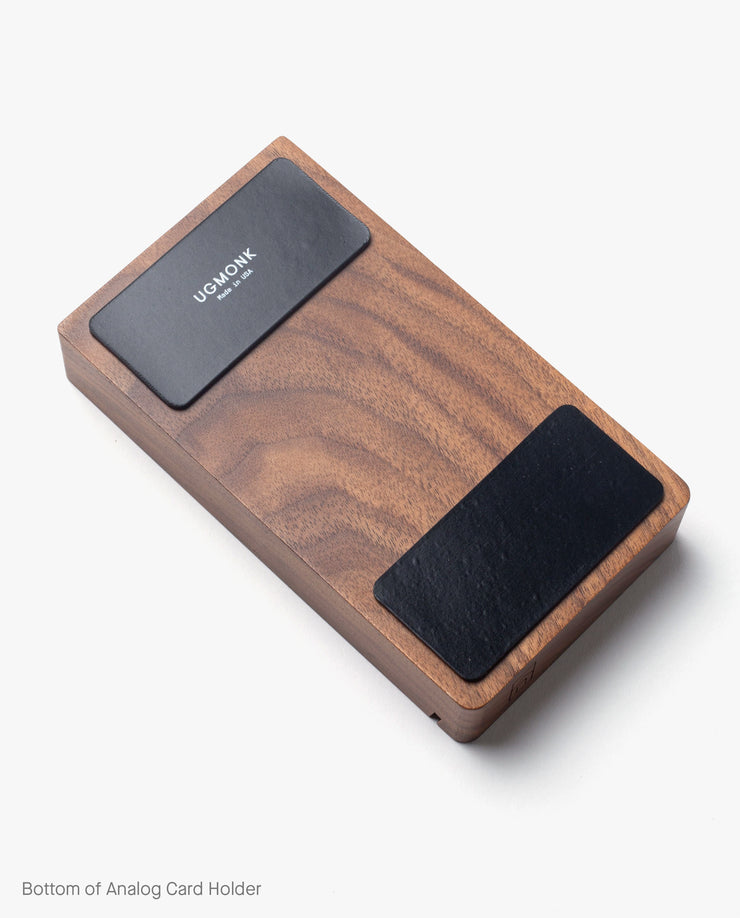 The Magnet Kit (For Analog Card Holder) includes two black adhesive magnets with the Ugmonk logo, designed for use on the underside of your rectangular wooden card holder. Featured against a white background.