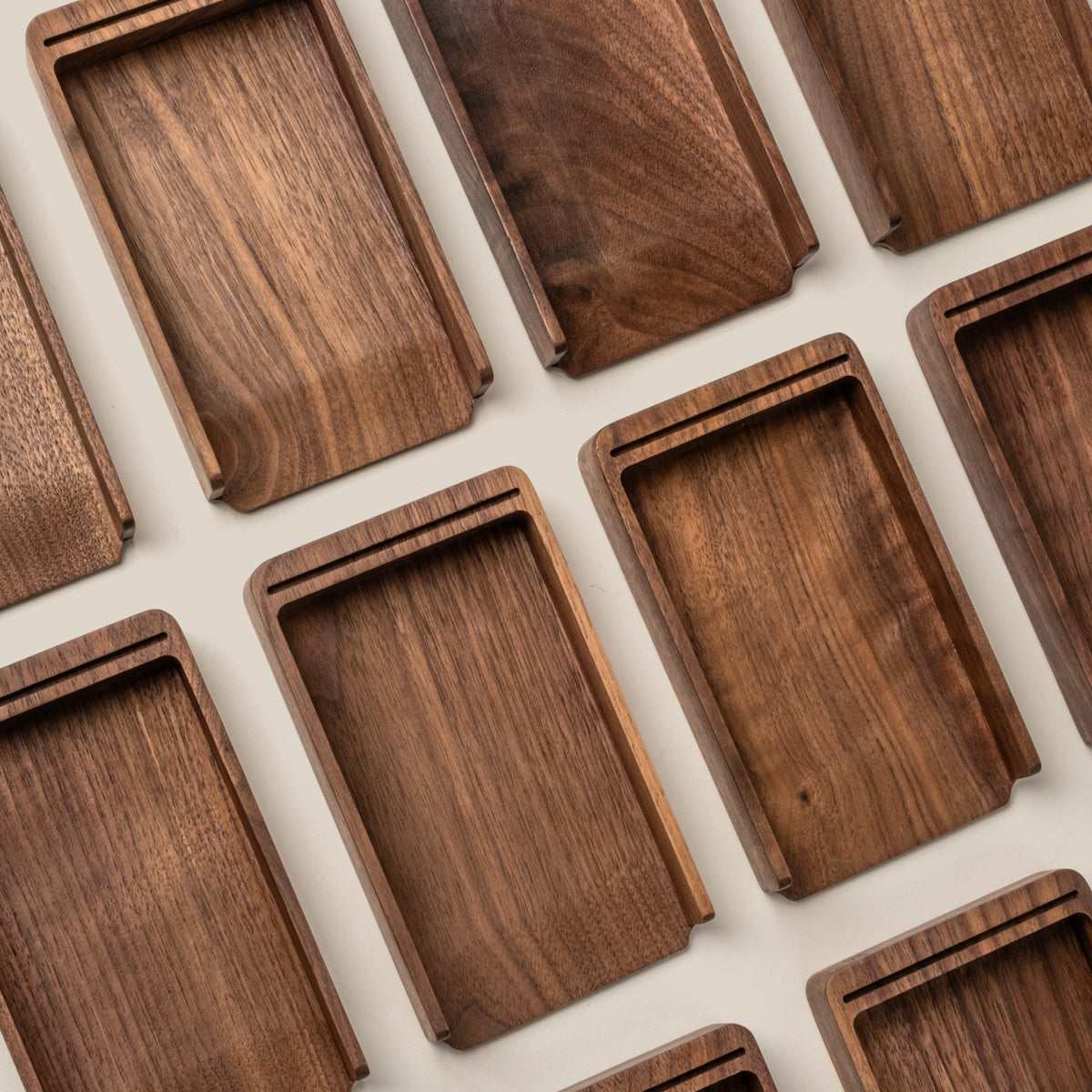Rectangular walnut trays with raised edges are arranged neatly, highlighting the rich wood grain—perfect for organizing your Analog Annual Kit (Walnut) and showcasing its warm tones on a light surface.