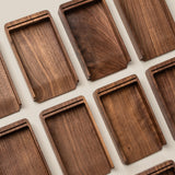 Rectangular walnut trays with raised edges are arranged neatly, highlighting the rich wood grain—perfect for organizing your Analog Annual Kit (Walnut) and showcasing its warm tones on a light surface.