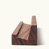 The Analog Weekly Card Holder (Walnut) features a handcrafted walnut design with a clear matte finish and grooved slot, made in Pennsylvania. Photographed on a plain light background, it’s ideal for displaying your Analog Weekly Cards in style.