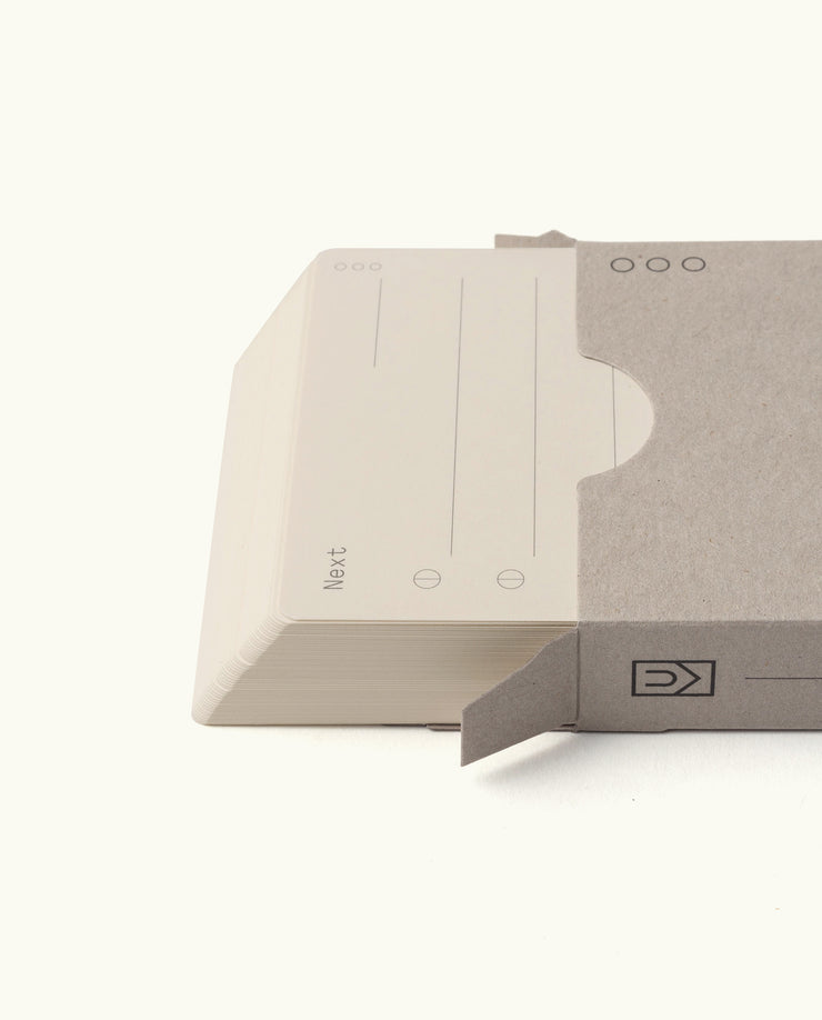 A stack of Analog – Next Cards (1-Pack) partially slides out of a plain, light gray sleeve. The top card features lines and circular checkboxes for goal setting, with a clean white background.