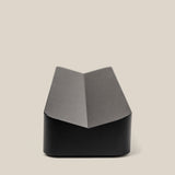 The Analog Pen Tray (Black Aluminum) features a sleek, angular design with a central crease, ideal as a modern desk organizer. Shown on a plain, light beige background, its minimalist style complements any workspace.