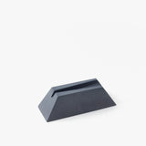 The Craighill Desk Knife Plinth (Slate) is a black, wedge-shaped cast concrete knife holder with a narrow slot on top, shown on a white background.