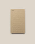A brown notepad inspired by the Analog - Someday Cards, featuring “Someday” printed at the top. Each page offers ten numbered lines for writing and a blank space for the date in the upper right corner—perfect for creative goal setting. The notepad is centered on a light beige background.